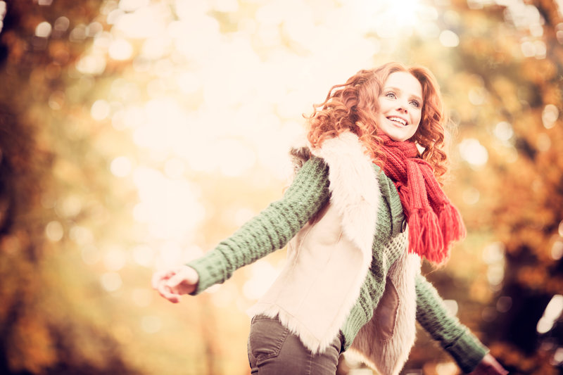 Freudige Frau im herbstlichen Wald