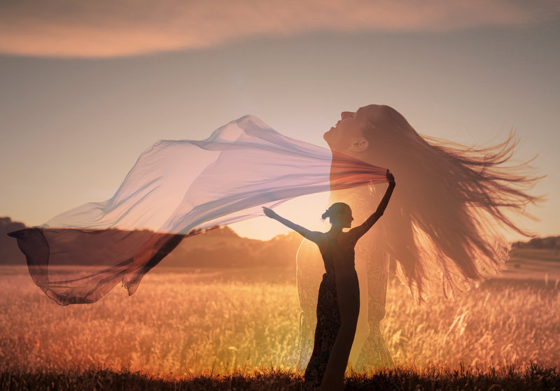 woman in the field feeling free at peace in nature holding